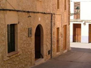 The facade of Casa De Pollenca in a quiet Pollenca street